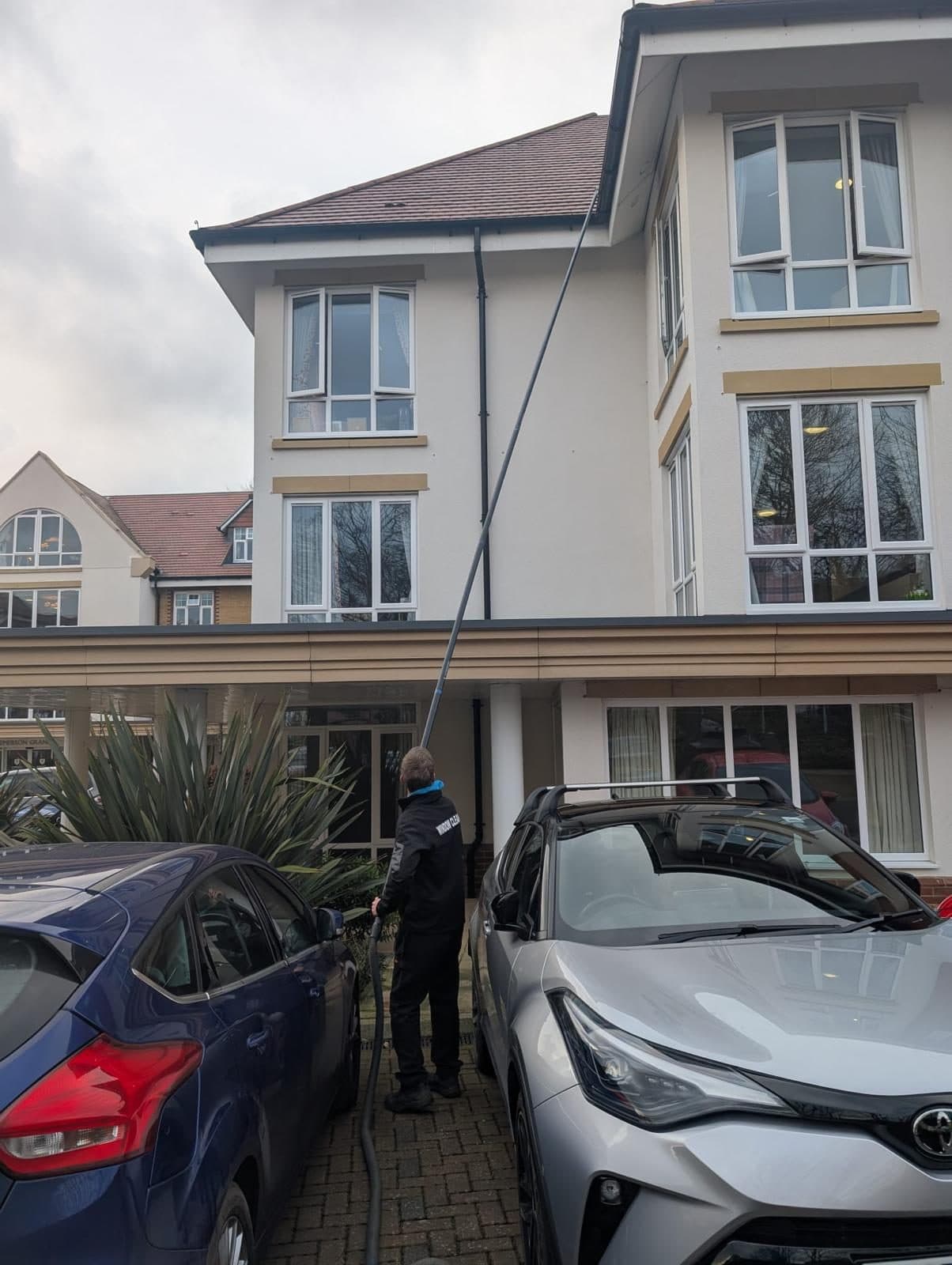 Water-fed pole reaching windows above a carport at a Southampton home